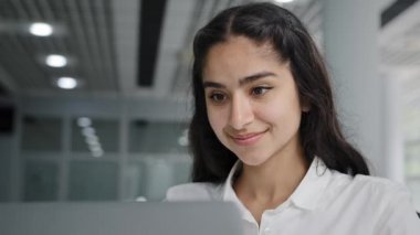 Close-up young cute funny woman office worker working on laptop satisfied girl manager finishing report reading good news dancing rejoicing in victory successful work showing ok sign approval gesture