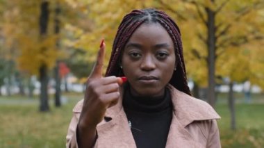 Yakın plan odaklı Afro-Amerikan kadın kameraya bakıyor. Birden beşe kadar sayıyor. Küçük etnik kız geri sayım gösteriyor.
