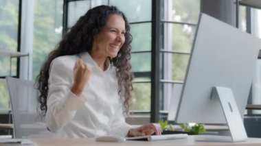 Genç İspanyol kadın ofis yöneticisi bilgisayarda yazarken mutlu mutlu kadın çevrimiçi piyango kazanıyor başarıyı kutlarken seviniyor zafer amacına ulaşıyor iyi haberleri okumak yeni fırsatlar elde ediyor.