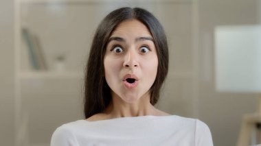 Emotional surprised female face arabic 20s young girlfriend millennial pretty ethnic woman student freelancer demonstrate positive wow reaction euphoria feel delight shock enjoyment successful triumph