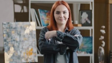 Ön manzara, beyaz dişli, mutlu ressam, hippi, kızıl saçlı kadın, resim çizdikten sonra kollarını kavuşturup fotoğraf çekerken kameraya gülümsüyor.