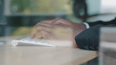 İş ortaklarıyla sohbet etmek için ofis bilgisayarını kullanarak modern kablosuz klavyede yazan bilinmeyen afro iş adamı lideri patron programcı bilişim uzmanı