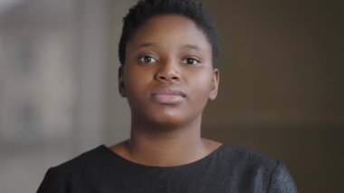 Ön cephe portresi sakin ciddi gururlu, üzgün, Afrikalı, Amerikalı, çift ırklı, kısa saçlı, doğal makyajlı bir kız.