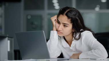 Bored sad lazy young indian woman manager sitting in office unmotivated uninterested in boring laptop work overworked tired sleepy businesswoman feeling tiredness experiencing lassitude exhausted work