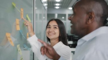 Şirket iş ortakları iş ortakları duvardaki kağıt not etiketlerine bakar iş tavsiyeleri verir iş tavsiyeleri verir görev yapısı yapışkan notlar ofis toplantısında beyin fırtınası takım çalışması