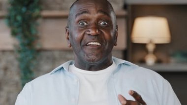 Afrikalı iyimser adam kıdemli Amerikalı yaşlı koç kameraya gülümseyen yaşlı baba koçu komik bir hikaye anlat hey el hareketi iyi fikir olduğunu gösteriyor tabanca ateşleme numarası yap