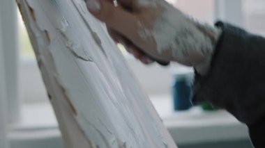 Yakın plan kadın eller kadın ressam tasarımcı bilinmeyen kız macun bıçağı kullanıyor yapışkan beyaz yapışkan dokuyu yayıyor branda üzerinde arkaplan oluşturuyor spatula ile pürüzsüz sanat tekniklerinin tadını çıkarın