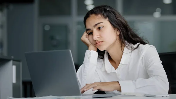 Bored sad lazy young indian woman manager sitting in office unmotivated uninterested in boring laptop work overworked tired sleepy businesswoman feeling tiredness experiencing lassitude exhausted work