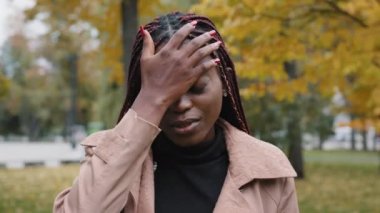 Genç, kederli, Afro-Amerikalı kadın, hata yüzünden avuçlarını utanç içinde tutuyor. Hayal kırıklığına uğramış kız, stresten dolayı utanıyor. Canı sıkkın bir kadın, elleriyle yüzünü kapatmakta zorlanıyor.
