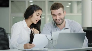 İki ofis çalışanı ortak proje çalışma verileri üzerinde çalışıyor. Raporlarda iş stratejisini tartışıyorlar. Kadın satış müdürü, müvekkiline ofis toplantılarında sigorta sözleşmesini açıklamasını öneriyor.