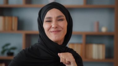 Portre dansı komik Arap kız Müslüman kadın siyah tesettürlü kadın kamera dansına bakıyor müzik eşliğinde el ele tutuşuyor ses hareketleri tatilin keyfini çıkarıyor mp3 radyosu