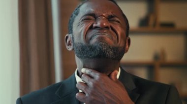 Yakın mesafede hayal kırıklığına uğramış, boğazı ağrıyan, boğazı ağrıyan, yutkunurken acı çeken, acı çeken, spazm geçiren, hasta, afrikalı erkek, kronik bademcik iltihabından muzdarip.