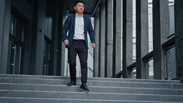 穿着正装的时髦投资人中年亚洲男人商人老板领袖人物走下楼梯走出写字楼 离开写字楼 奔向户外见面 — 图库视频影像