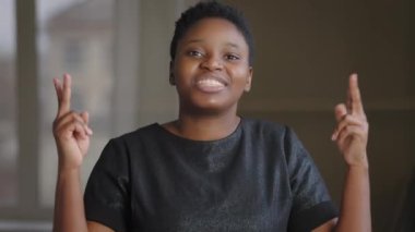 Afro-Amerikan melez kadın mutlu duygusal kız kapalı bir yerde kameraya bakıp parmaklarını göstererek haklı olduğunu söylüyor.