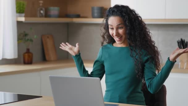 女性実業家は オンラインで通信する手非公式に優しい挨拶を振ってビデオチャットでクライアントや友人遠くのウェブカメラの会話とチャットコンピュータ画面上でチャットを見て自宅のキッチンに座って — ストック動画