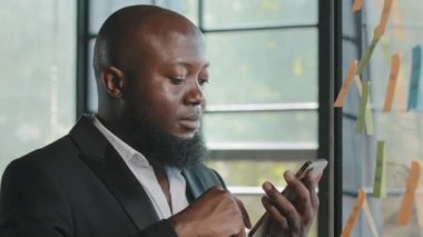 Afrika kökenli Amerikalı işadamı, akıllı telefondan haberleri okuyup internetten rezervasyon yaptırıyor. İş telefonu uygulamalarını kullanarak sosyal ağlarda sensör görüntüleme sohbeti yapıyor.