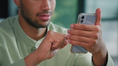 Yarım suratlı Afro-Amerikan sakallı adam kapalı bir yerde elinde akıllı telefon olan erkek müşteri işadamı cep telefonuyla ana ofiste oturup mobil uygulama kullanarak ekranda arama yapıyor.