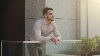 Latin kökenli, Latin kökenli, işadamı, işveren, balkonda duran modern gökdelen ofis binası inşaatında çalışan, şehir sokaklarını düşünen rahat bir işadamı. Yüksek
