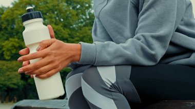 Bilinmeyen sporcu sağlıklı kadın koşucu spor kıyafeti giyer sıkı antrenmanlardan sonra dinlenir dinlenir spor molası verir filtreli su şişesini rahat bırak