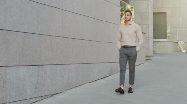 Latin kökenli iş adamı sakallı patron patron yönetici yönetici başarılı işçi yatırımcı yürüyüşüne çıkıyor şehir merkezine gidiyor şehir merkezindeki binaya bakıyor şehir merkezindeki ofise taşınıyor