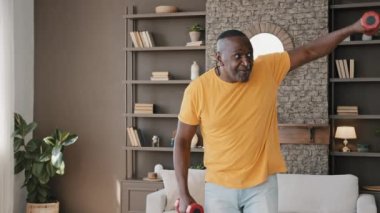 Sporcu Afrikalı kıdemli fitness sporcusu sağlıklı yetişkin sporcu spor aletleri kullanarak ritmik egzersizler yapıyor. Sırt ağrısı, omurga sakatlığı, rutin egzersizler.
