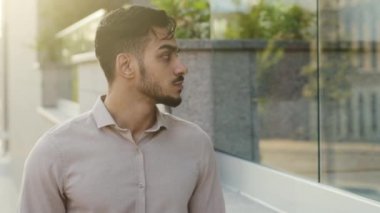 Erkek tüketici müşterisinin portresi vitrinlere bakarak caddede yürüyor. Hispanik sakallı dalgın iş adamı şehirde yürürken Latin turistin şehir dışına gittiğini düşünüyor.