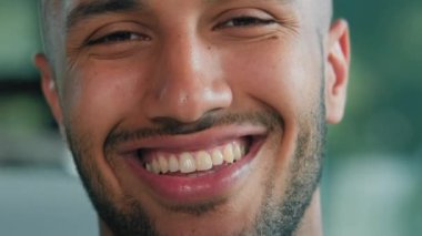 Yakın çekim erkek portresi neşeli neşeli kaygısız Afrikalı Latin adam müşteri iş adamı sağlıklı sakallı patron iş adamı beyaz dişli diş tebessümü kameraya bakıyor.