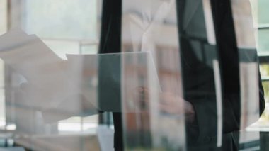 Camsı duvar manzaralı analistin arkasında modern ofiste çalışan işadamı denetçisi finansal belgeleri okuyor iş sözleşmesi ödeme bildirimi kurumsal bankacılık belgeleri tebligat kredi