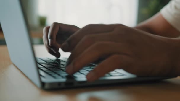 認識できないアフリカのラテン系男性の男性の手を閉じるテーブルの上にノートパソコンのキーボードを入力オンライン作業コンピュータアプリでリモート研究賭けビジネスチャットテキストメッセージ暗号通貨プロジェクトでネット — ストック動画
