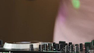 Tanınmayan Afrikalı Amerikalı erkek DJ elektronik müzisyen gece kulübünde disko müziği çalıyor hip-hop tekno ritim çalan adamla dans ediyor festival sahnesinde çok renkli neon ile komik dans ediyor.