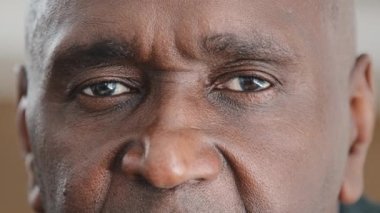 Aşırı yakın çekim makrosu, erkek kırışık Afrikalı yüzü çekiyor. Kameraya siyah gözlerle bakıyor. Yüzü tanınmaz halde.