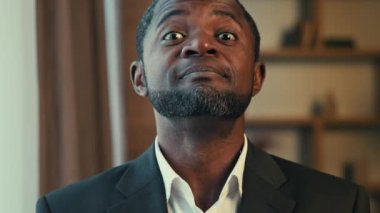 Kendine güvenen Afro-Amerikan iş adamı portresi, kameraya bakıyor, başını sallıyor, evet diyor, olumlu cevap veriyor.