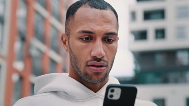 Şehirde Gündelik Spor Giyim Standında Oturan Endişeli Latin Adam Telefon — Stok video