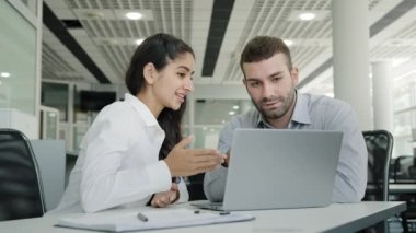 Kadın profesyonel yönetici danışman satış elemanı dizüstü bilgisayardaki erkek müşteri erişilebilirlik ürünlerini İnternet 'te çalışan iş arkadaşlarının ofiste oturan takım çalışması için sipariş vermelerine yardımcı oluyor.