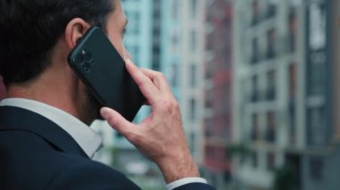 Şehir merkezindeki caddenin dışında iş görüşmesi yapan erkek işadamı danışmanı sohbet cep telefonu müşterisiyle iş anlaşmasını tartışırken uzaktan kablosuz cep telefonu bağlantısı mesafesi görüşmesini kişisel sohbete yönlendir