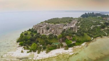 Avrupai tatil beldesi Sirmione 'deki tarihi havacılık manzarası Garda Gölü' ndeki tarihi ada tarihi tarihi tarihi tarihi tarihi tarihi tarihi tarihi tarihi tarihi turistik mekan Catullus kalesinin kalıntılarını harabeye çevirdi.