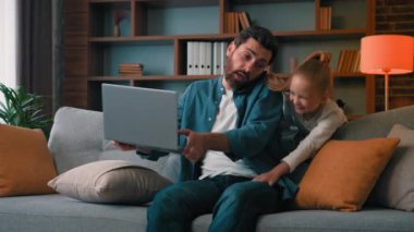 Gürültücü yaramaz kız, kötü davran, babanın dikkatini dağıt. Evde dizüstü bilgisayar başında rahatsız bir adam var. Telefona cevap ver.