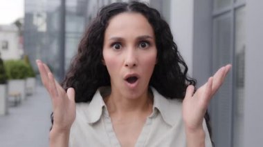 Oh my god wow female facial reaction close up. Amazed excited shocked wonder Caucasian woman girl raising hands in surprise unbelievable news victory winning looking at camera with big eyes outdoors