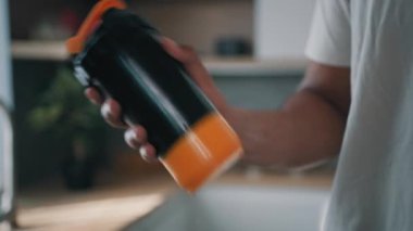 Tanınmayan Afro-Amerikan güçlü sporcu erkek sporcu kapalı alanlarda şişe karıştırıcıyı sıvı kalsiyumla sallıyor protein kokteyli sporları sağlıklı beslenme vücut geliştirme diyetini destekliyor.
