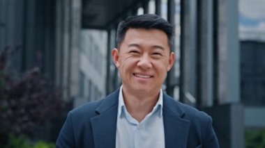 Şehirdeki en ön planda Asyalı adam iş adamı patron şirket CEO 'su mutlu orta yaşlı iş adamı profesyonel mali danışman yönetici erkek avukat gülümsüyor