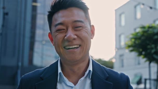 幸せな男性アジアの中高年ビジネスマン街で心から屋外で笑っている男感情的に笑顔冗談面白い状況で楽しい気分でユーモアの喜び屈託のない仕事の日を獲得 — ストック動画