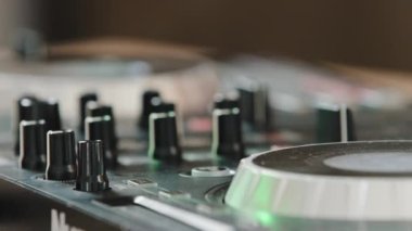 Tanımlanamayan Afrikalı DJ, ses efektlerini kullanarak gece kulübünün elektronik müziğinde yeni şarkılar besteleyen müzik karıştırıcı kontrolöründe düğmeye basıyor.