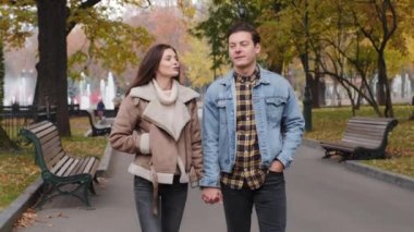 Genç çiftler, kaygısız sevgililer sonbaharda şehir parkında sokak arasında yürüyorlar. Kafkasyalı erkek ve kadın, hafta sonlarını dışarıda el ele tutuşarak geçiriyorlar. İki kişi için romantik bir randevu.