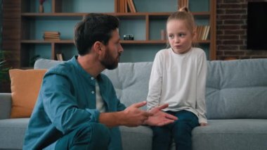 Önemseyen beyaz bir baba, gücenmiş bir çocukla iletişim kurmaya çalışan bir baba, küçük bir çocuğa yardım ediyor ve aile içinde çocuklar ve ebeveynler arasındaki yanlış anlaşılma sorunu hakkında samimi bir şekilde konuşuyor.