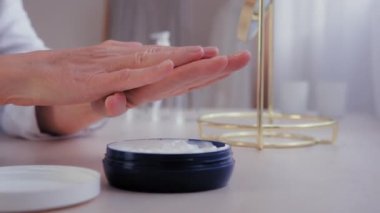Tanımlanamayan yaşlı beyaz kadın kadın eli cilt bakımı. Kuru cilt için yaşlanma karşıtı krem sürme. Bilinmeyen yaşlı kadın günlük nemlendirici vitamin losyonu.