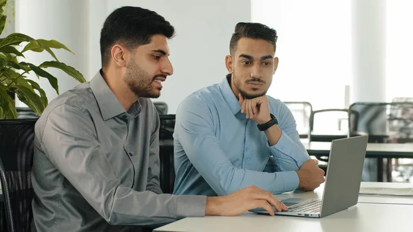 Dva Indičtí Zaměstnanci Sedí Moderní Kanceláři Notebookem Mladí Kolegové Diskutují — Stock fotografie