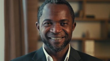 Yakın plan erkek iş portresi. Mutlu, kendinden emin, başarılı iş adamı, ofiste poz veren memnun müşteriye bakan mutlu, Afro-Amerikan adam.