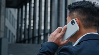 Tanımlanamayan Asyalı resmi takım elbiseli bir adam şehirde dikilip akıllı telefon konuşmaları yapıyor. Patron, girişimci işadamı ve iş adamı dışarıda cep telefonu konuşmaları yapıyor.
