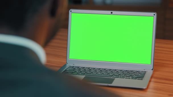 バック認識できない男からの眺めビデオ通話で話している緑のラップトップ画面のビジネスマンを見てウェブカメラ教師を介してオンライン会議で通信現代のコンピュータ技術を使用してウェビナーを開催しています — ストック動画