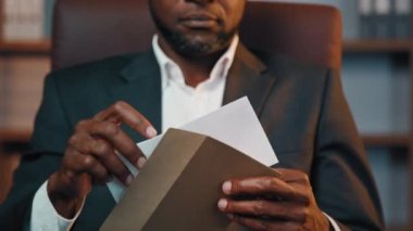 Ciddi afro-amerikan iş adamı, ev ofisinin açılış mektubunda üzgün bir şekilde oturuyor. Kötü haberleri okuyan adam, banka kredisinin reddedilmesiyle iflasın hüsranına uğruyor.